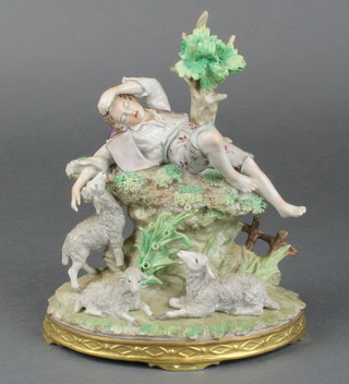 An early 20th Century Sitzendorf figure of a sleeping boy shepherd surrounded by sheep on a raised rocky outcrop and gilt base 8" 