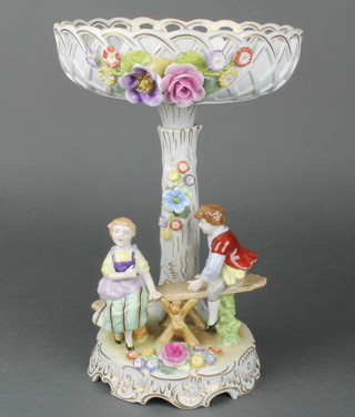 An early 20th Century Plaue centerpiece encrusted with flowers, the base with 2 children on a seesaw, on a raised rococo base 12" 