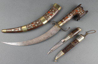 A "Turkish" dagger with 8 1/2" blade contained in a hardwood and inlaid metal scabbard together with 1 other Continental dagger with 3 1/2" blade contained in a leather and white metal scabbard 