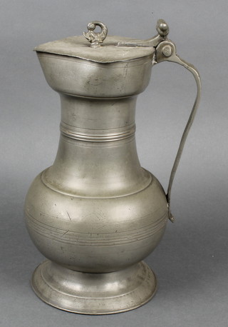 An 18th Century Continental bell shaped lidded pewter jug with acorn thumb piece, the lid marked LXXVNF  11" 