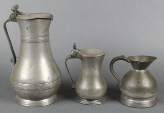 An 18th Guernsey pewter lidded jug of waisted form with acorn thumb piece 8",a smaller Jersey ditto 5" and a VIctorian pewter harvest measure 4 1/2" 