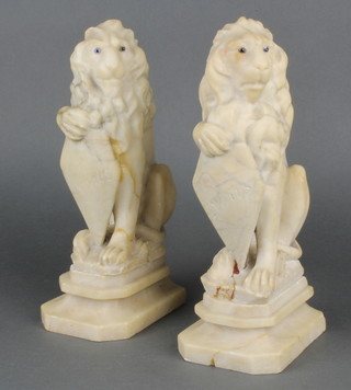 A pair of carved marble figures of seated lions, raised on rectangular bases 10"  