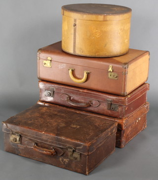 A brown leather suitcase with chrome mounts 7 1/2" x 26"w x 16"d, a similar brown leather case with brass mounts 6" x 26" x 14 1/2" (stitching damaged), 1 other 8"h x 24"w x 15"d (stitching damaged), a further brown leather suitcase with brass fittings 8"h x 26"w x 15"d and a circular plywood hat box 11"h x 18" diam. 

