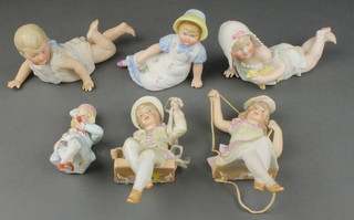A pair of German bisque figures of a boy and girl on a swing 6", 3 reclining figures and a seated figure of a boy 