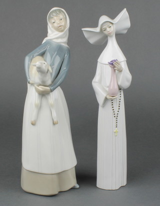 A Lladro figure of a girl carrying a lamb 10 1/2" and a ditto figure of a nun 5550 10 1/2" 