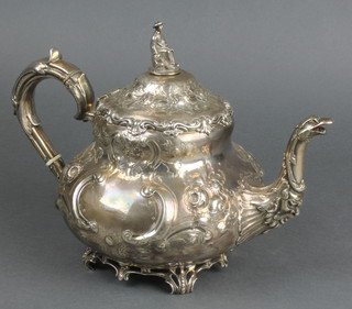 A mid Victorian repousse silver bulbous teapot with C scroll handle and spout in the form of a bird, the finial in the form of a seated chinaman bearing an armorial with ivory resistors Sheffield 1885, 26 ozs 