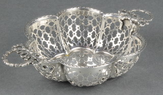 A silver pierced 2 handled bowl with ribbon handles with a later plated inset base 