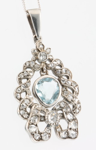 An 18ct white gold aquamarine and diamond open ribbon pendant on a ditto chain 