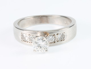 A 14ct white gold raised mount diamond ring, the centre stone flanked by 2 brilliant cut stones, size I