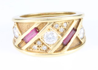 An 18ct yellow gold wide diamond and ruby set ring, comprising 3 brilliant cut diamonds and 2 baguette cut rubies, size G 