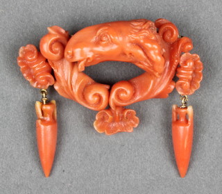 A Victorian Greco Roman style carved coral brooch in the form of a rams head with amphoras  