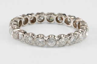 A white gold 21 stone diamond eternity ring in a rub over setting, size N