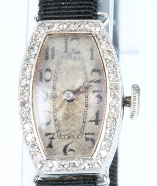 A lady's Art Deco tonneau shaped platinum and diamond cocktail watch on a silk strap