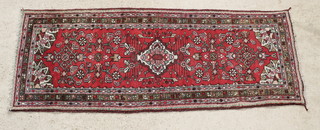 A Navahand Persian red ground and floral patterned runner with multi row borders 77 1/2" x 30 1/2" 