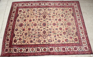 A Mashad tan ground and floral patterned carpet, signed, some wear  148" x 113" 
