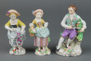 A pair of early 20th Century Sitzendorf figures of ladies - one carrying a basket of flowers and the other trimming a flower 3", together with a ditto figure of a seated gardener 4" 