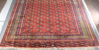A red ground Bokhara carpet with 80 octagons to the centre 129" x 101" 