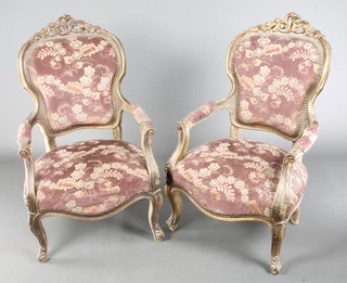 A pair of Louis XIV style carved and pierced gilt wood open arm chairs, the seats and backs upholstered in sculpted Dralon 