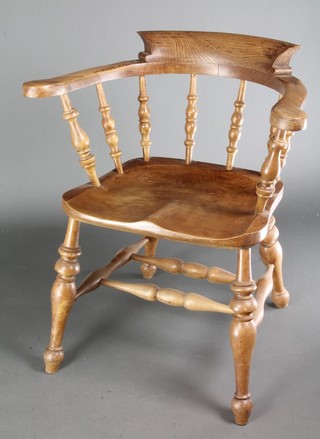 A Victorian oak smoker's bow chair with solid seat and H framed stretcher on turned supports 