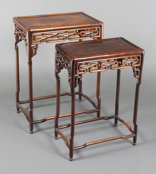 A pair of rectangular Chinese Padouk wood interfitting coffee tables with carved pierced aprons, largest 21"h x 17 1/2"w x 11", smallest 22"h x 15 1/2"w x 9 1/2"d