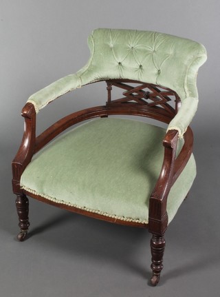 An Edwardian carved and pierced walnut tub back chair upholstered in green buttoned dralon, raised on turned supports 