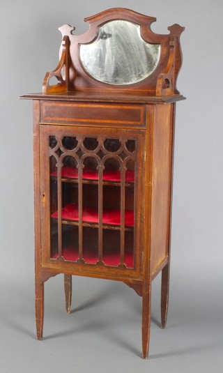 An Edwardian inlaid mahogany music cabinet, the shield shaped raised back fitted a bevelled plate mirror, fitted shelves enclosed by astragal glazed panelled doors 54"h x 14"w x 23"d 