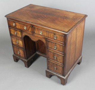 A Victorian kneehole pedestal desk with crossbanded top, fitted 2 short drawers above a secret drawer above 6 short drawers, the pedestal fitted a cupboard enclosed by panelled door, raised on bracket feet 30"h x 36"w x 20 1/2"d  