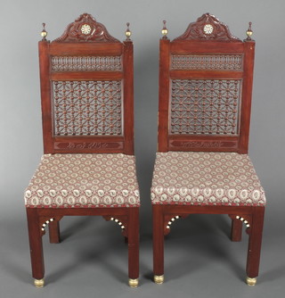 A pair of Moorish style hall chairs with pierced backs and inlaid decoration raised on square tapered supports