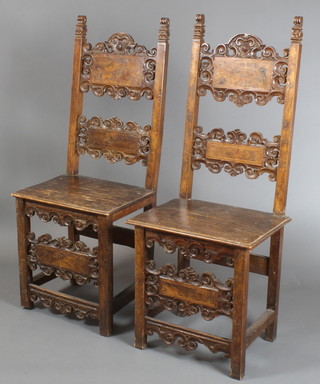 A pair of Spanish early 17th Century carved walnut high ladder back hall chairs with solid seats, carved and pierced aprons 