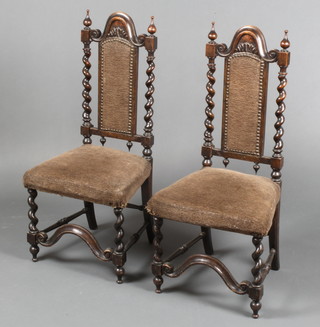 A pair of Victorian Carolean style mahogany nursing chairs with spiral turned columns to the sides and wavy stretcher, upholstered in brown material  