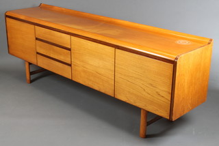 A 1960's G Plan style teak sideboard with shaped top, fitted 3 drawers flanked by cupboards 30"h x 82"w x 18"d 