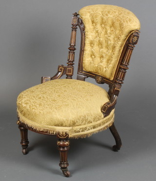 A Victorian nursing chair upholstered in yellow buttoned material on turned supports with turned columns to the sides 
