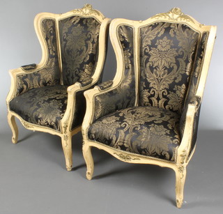 A pair of French style white painted show frame armchairs upholstered in black and gold material, raised on cabriole supports