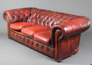 A Chesterfield 3 seat settee upholstered in red buttoned back leather 28"h x 82"w x 37"d 