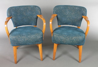 A pair of 1950's walnut open arm chairs, the seats and backs upholstered in blue material (frames are loose) 