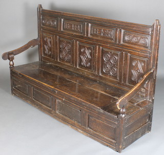 A carved oak settle, the raised panelled back marked 16MB20, the base fitted a hinged lid 45"h 