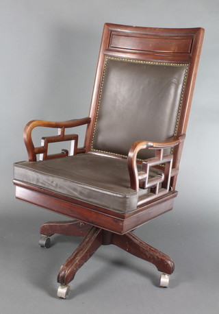 A Chinese hardwood revolving office chair with upholstered seat and back 