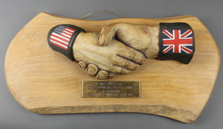 A resin and oak plaque in the form of 2 clenched hands marked "Meeting again after memories of a lifetime is certain for those who are friends" 15"