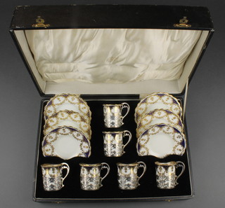 Six Aynsley coffee cups and saucers with pierced silver holders London 1932