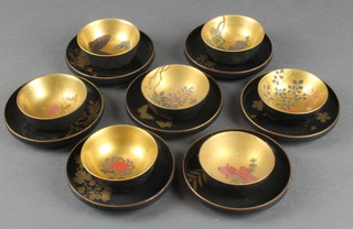 Seven Chinese black lacquered tea bowls and saucers with floral decoration 