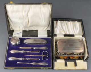 A silver engine turned cased 7 piece manicure set and a cased silver brush and comb