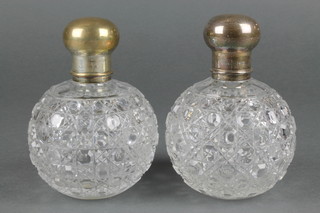 A near pair of cut glass spherical scents with silver covers 5 1/2" and 6in
