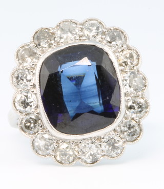 A white gold cushion cut sapphire and diamond cluster ring, the centre stone surrounded by 16 brilliant cut diamonds, size N 
