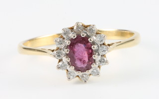 An 18ct yellow gold ruby and diamond oval cluster ring size Q1/2