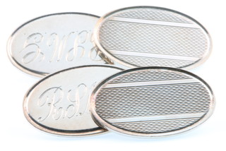 A pair of oval silver cuff links and a ditto tie clip