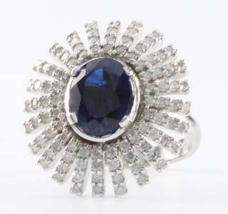 A 14k white gold oval cut sapphire (approx 4.6ct) and diamond sun burst ring Size N