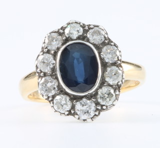 An 18ct yellow gold oval sapphire and diamond cluster ring Size N