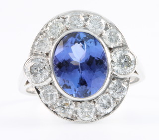 An 18ct white gold oval tanzanite and diamond cluster ring the centre stone approx. 2.60ct surrounded by 12 brilliant cut diamonds approx. 0.60ct, size P