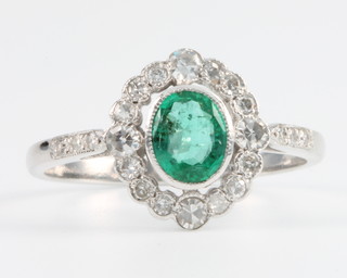 An 18ct white gold emerald and diamond cluster ring Size P