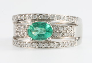 An 18ct white gold emerald and diamond dress ring with a centre cut emerald surrounded by 46 brilliant cut diamonds, size N